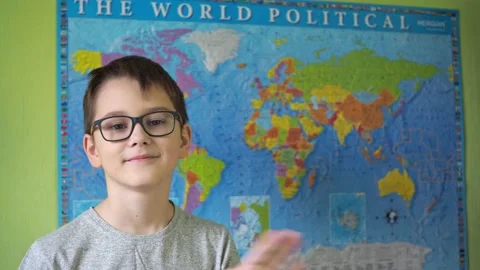 A boy with glasses waves his hand standing against the background of a political Stock Footage 167156910