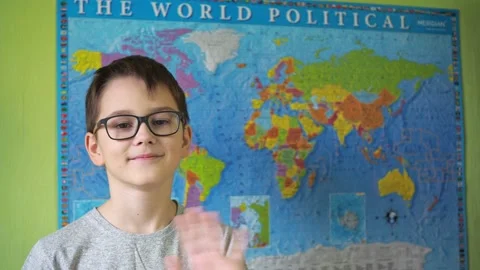 A boy with glasses waves his hand standing against the background of a political Stock Footage 167796483