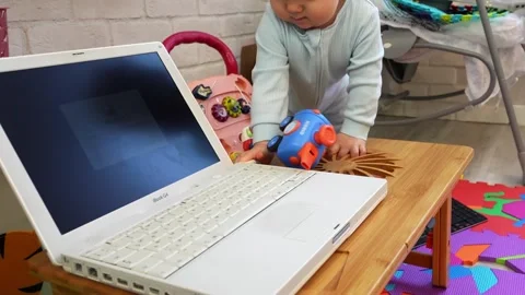 A boy gleefully plays with a laptop Stock Footage 266751595