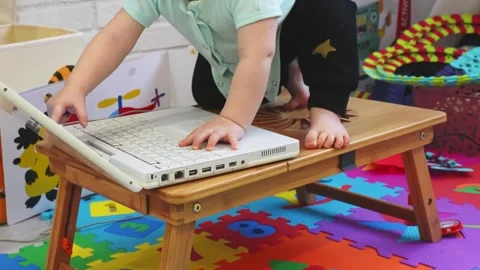 A boy gleefully plays with a laptop Stock Footage 266751619