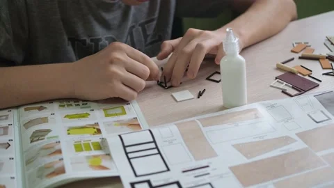 The boy glues a model on the table. close-up of the hands gluing the parts Stock Footage 170447133