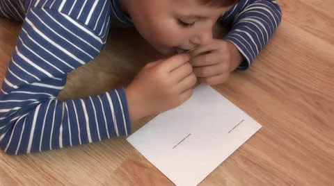 Boy glues stamp on a letter Vidéo 12227652