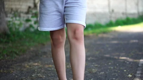 The boy goes to the camera legs close-up. walk on the street Stock Footage 248378592
