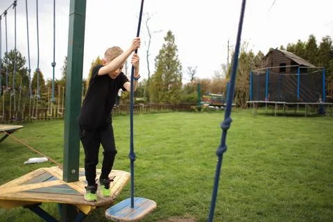 The boy goes through an obstacle course is engaged in active sports to hold o Stock Photos