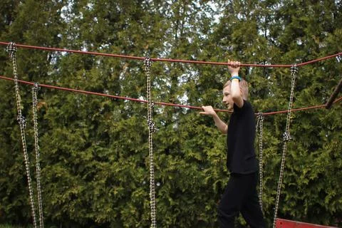 The boy goes through an obstacle course, goes in for active sports, walks on  Foto stock