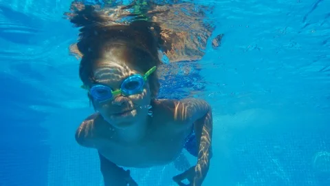 Boy in goggles swimming in pool Stock Footage 103936597