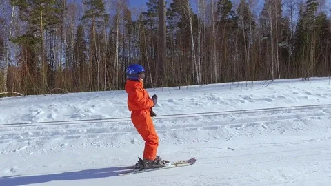 Boy going up a hill using one button ski lift. Stock Footage 77537480