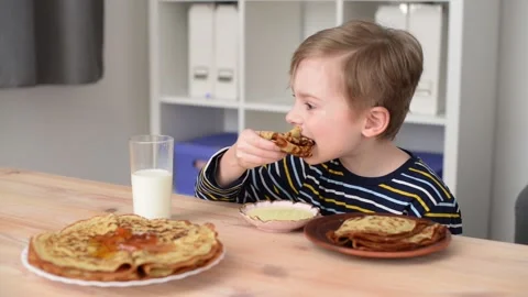Boy with a good appetite eats pancakes Stock Footage 194566207