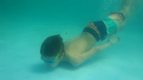 Boy in googgles dives in blue pool outdoors Stock Footage 51719625