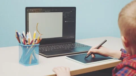 A boy on a graphic tablet draws a smile Stock Footage 150185697