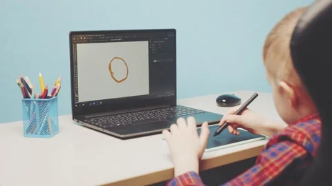 A boy on a graphic tablet draws the sun Video stock 150185628
