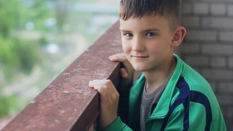 A boy in a green windbreaker posing for the camera. High floor view Stockbeeldmateriaal 108626385