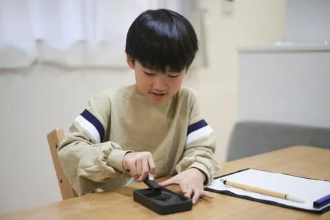 Boy grinding ink Stock Photos