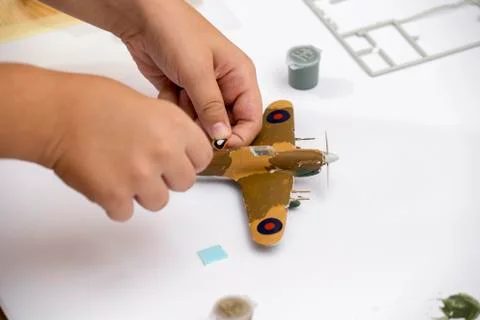 Boy hand applying waterslide decal to plastic model Stock Photos