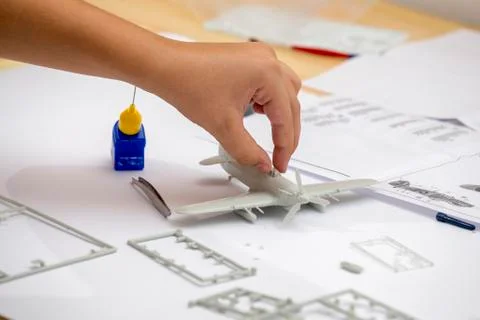 Boy hand assembling plastic model kit of ww2 aircraft Stock Photos