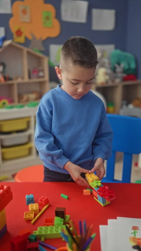 Boy hand placing colorful block on red table while stacking a tall tower in.. Stock Footage 339153654