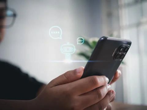 A boy hand uses a smartphone to type live chat, ask, answer with an artific.. Stock Photos
