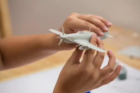 Boy hands assembling plastic model kit of ww2 aircraft Stock Photos