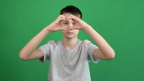 Boy hands making heart shape gesture on green screen chromakey background Stock Footage 151277599