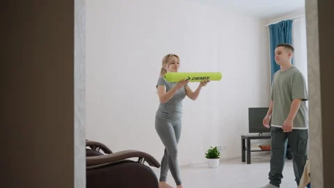 Boy Hands Over Yoga Mat To Sister Indoors Видео 321090182
