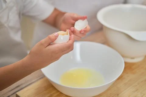 Boy hands separating the egg white from the yolk for the pie Stock Photos