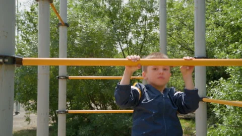 Boy Hanging on Horizontal Bar During Outdoor Workout Stock Footage 328635515