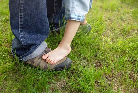 Boy is happy with his first steps supported by his father on a meadow Foto stock