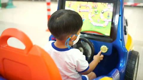 Boy happy with simulation car toy control in supermarket Stock Footage 142210682