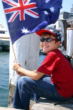 Boy on harbourside pier waving flag Stock Photos