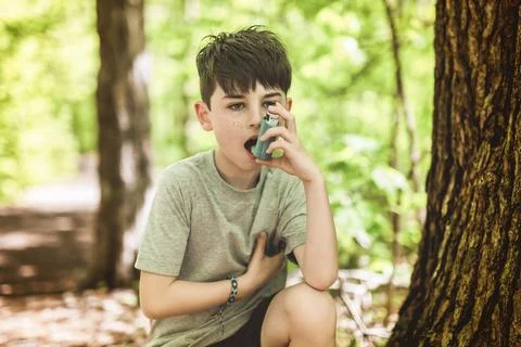 Boy has an asthmatic agent in his hands in the park backgrounds. The boy in the Foto stock