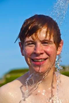 Boy has a shower at the beach Stock Photos