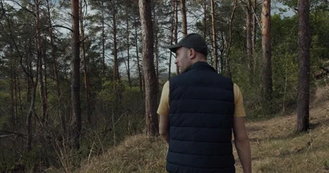 A boy with a hat on his head, walking in the city park at sunset. Video stock 138640659