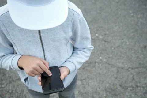 Boy with hat looking at smartphone Stock Photos