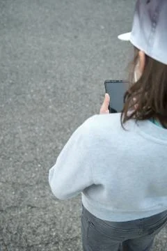 Boy with hat looking at smartphone Stock Photos