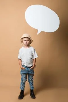 A boy in a hat stands on an orange background and shows emotions Stock Photos