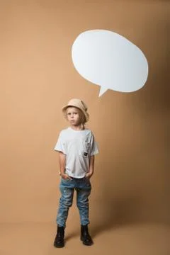 A boy in a hat stands on an orange background and shows emotions Stock Photos