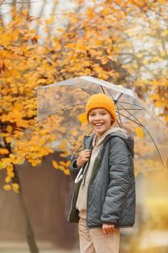 Boy in a hat with a transparent umbrella Stock Photos