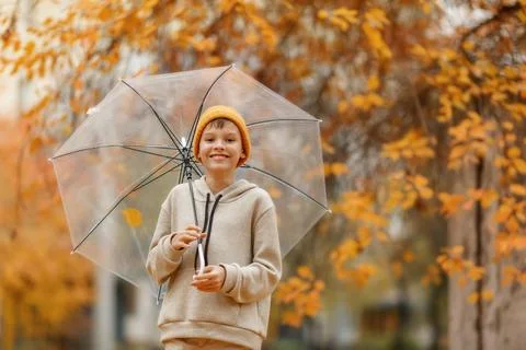 Boy in a hat with a transparent umbrella Stock Photos