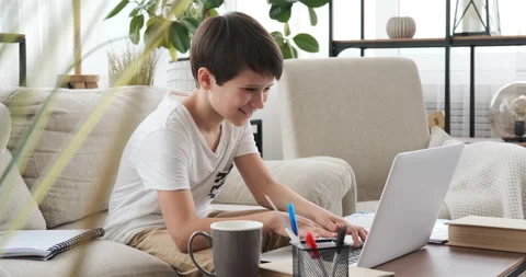 Boy having fun chatting after studying online at home Stock Footage 133197642