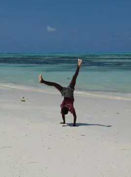 Boy having fun doing handstand on Jambiani beach, Zanzibar, Tanzania Stock Photos