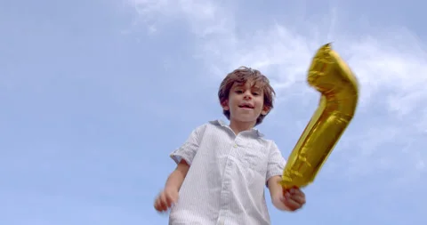 A boy having fun jumping at trampoline with an inflatable number seven Stock Footage 161957594