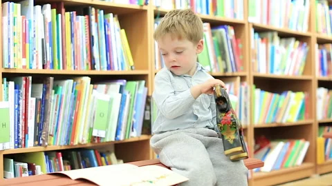 The boy is having fun in the library Stock Footage 210562761
