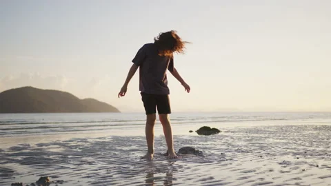 Boy having fun playing on the sea beach with sand at sunset. The concept of Stock Footage 191462830