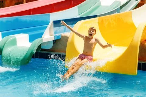 Boy having fun sliding in water park Stock Photos