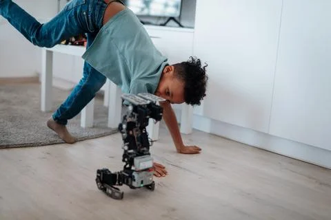 Boy having fun with small robot at home as part of STEM learning. Foto stock