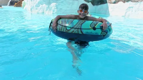 Boy Having Fun in the Swimming Pool On Inner Tube. Summer Vacation Fun. Stock Footage 169954277