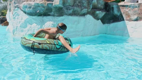 Boy Having Fun in the Swimming Pool On Inner Tube. Summer Vacation Fun. Stock Footage 169955542