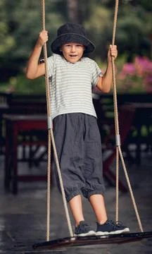 Boy having fun on the swing Boy having fun in the park on a swing ,model r... Photos