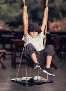 Boy having fun on the swing Boy having fun in the park on a swing ,model r... Stock Photos