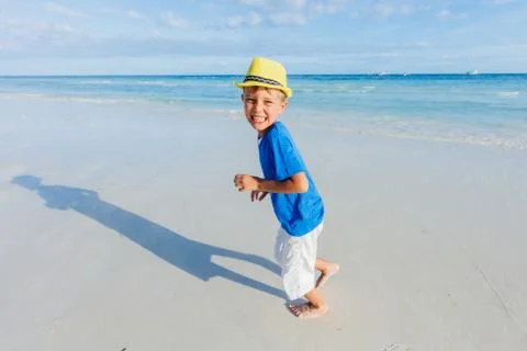 Boy having fun on tropical ocean beach. Kid during family sea vacation. Фото